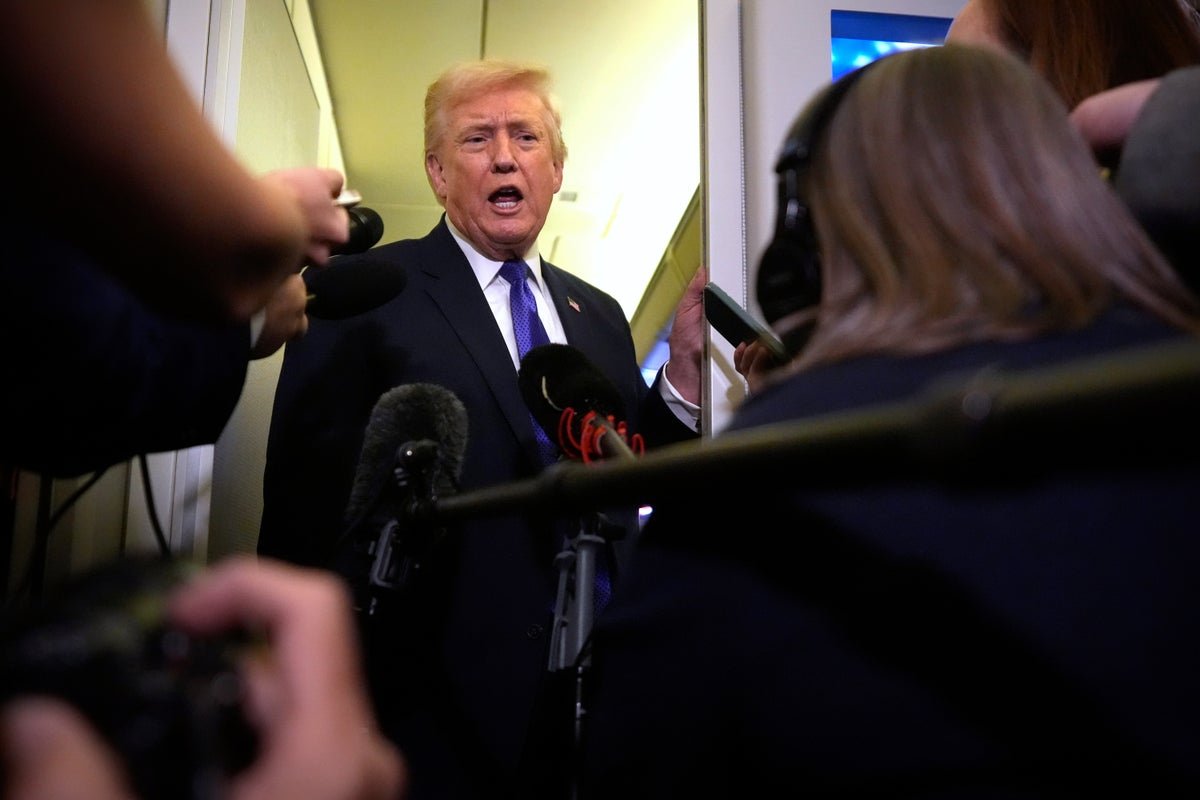 Donald Trump speaking at a podium, with a crowd of people in the background, highlighting the controversy surrounding his immigration agenda and the split in his MAGA base