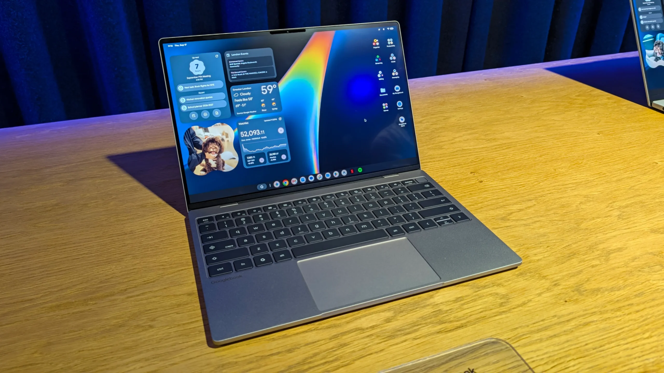 A Googlebook laptop displaying Android desktop interface beside a Samsung Galaxy S25 smartphone.
