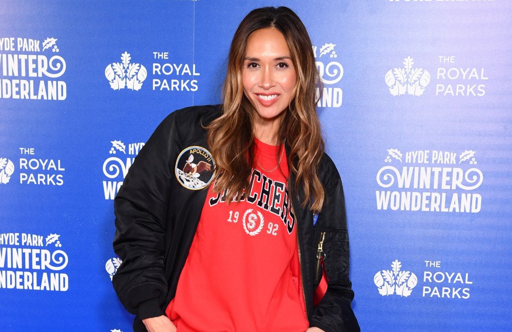 Myleene Klass smiling, surrounded by beautiful flowers and elegant wedding decorations, embodying the essence of a unique wedding celebration