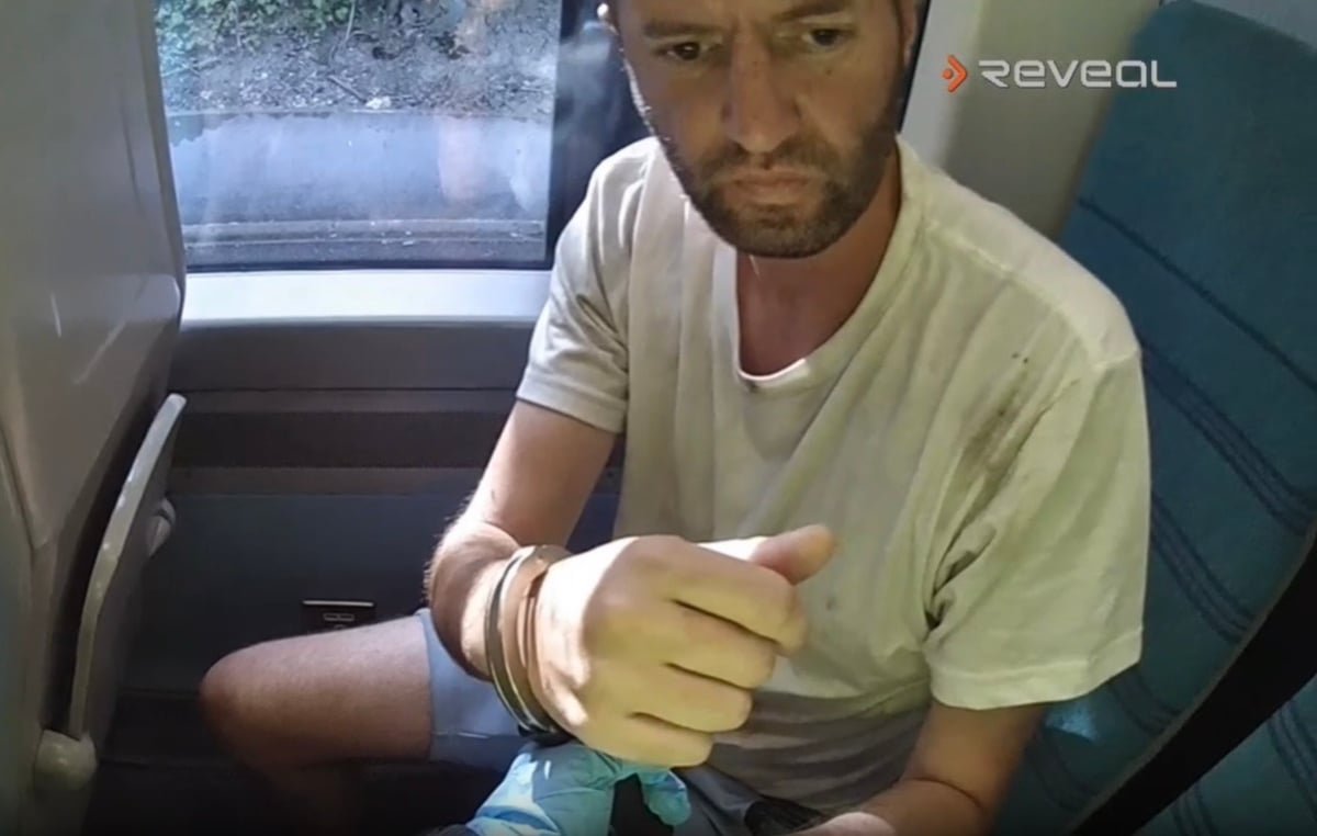 A woman looking uncomfortable on a train as a man in the background is allegedly masturbating, highlighting the importance of public transport safety and the need to report suspicious behaviour, with a focus on the train pervert