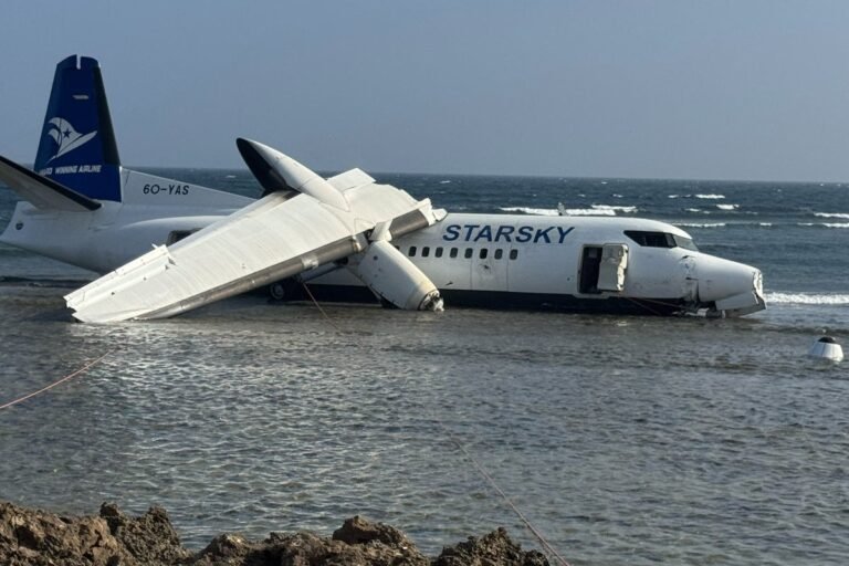 A photo of a plane crashing into the sea off the Somali coast, with rescue teams and passengers in the foreground, highlighting the heroic actions of the pilot in saving lives