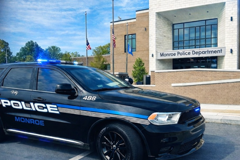 A young boy sitting in the driver's seat of a car, looking worried and surprised, with a police officer standing next to the vehicle, emphasizing the primary keyword of underage driving