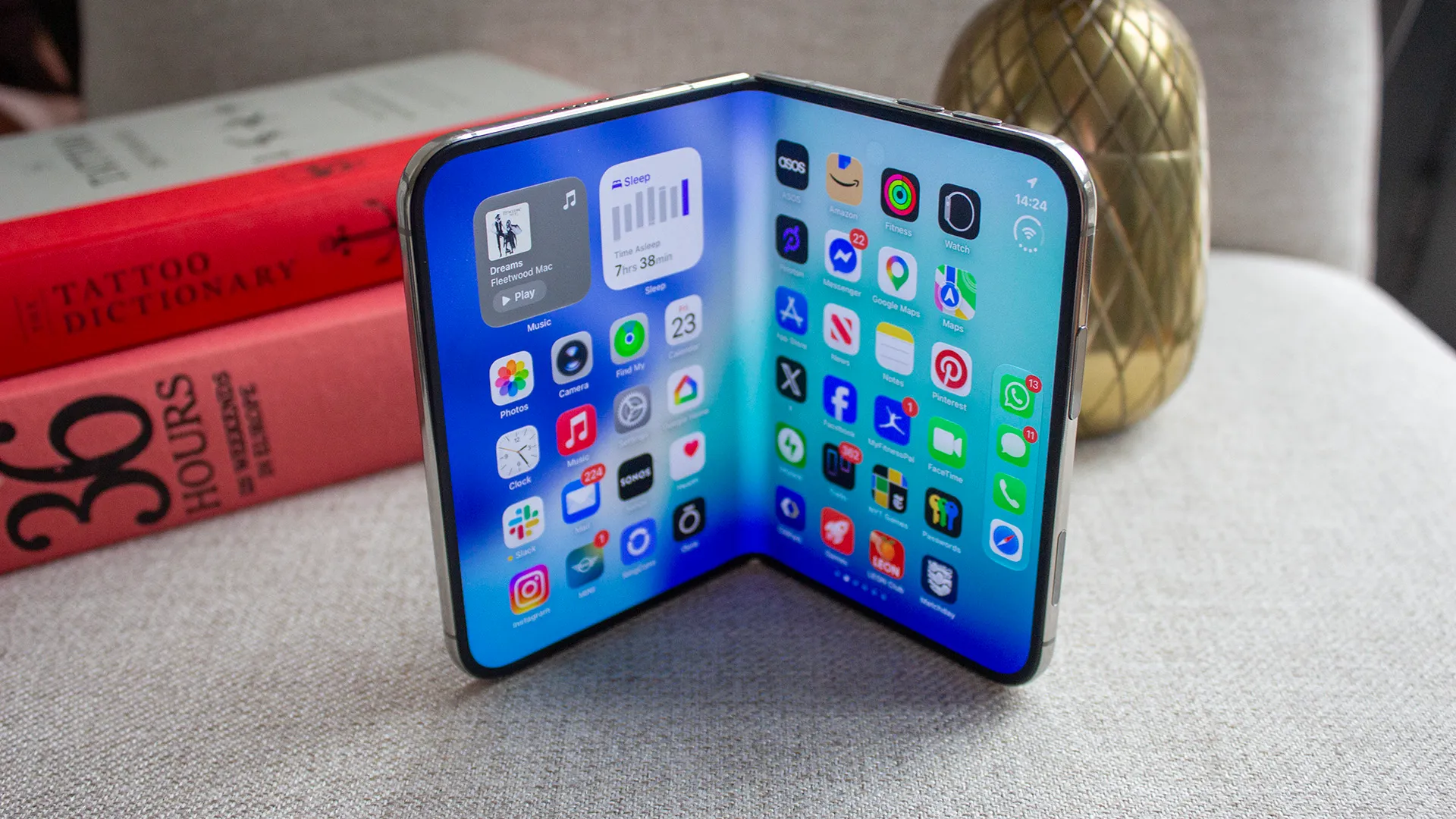 Apple iPhone Duo open showing its titanium frame and matte inner display beside a Samsung Galaxy Z Fold 8