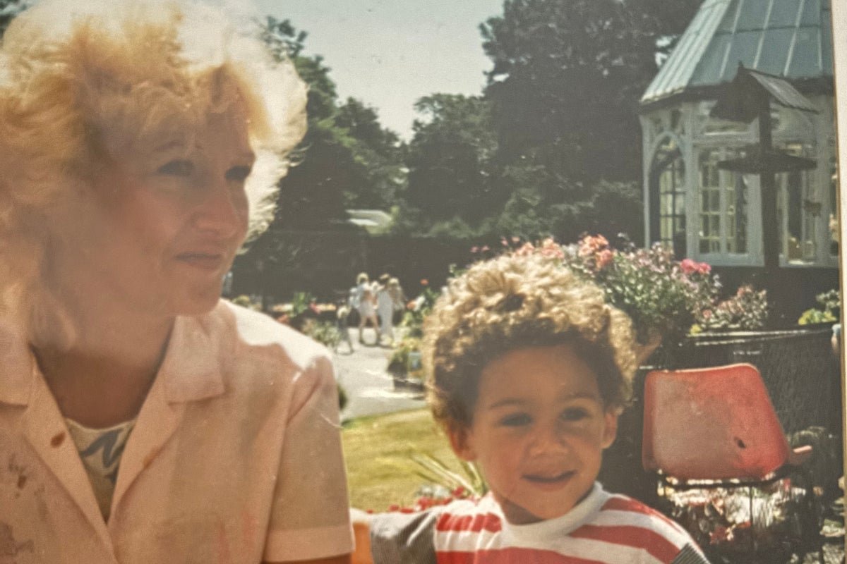 A mother holding a photo of her missing son, with a concerned expression, highlighting the importance of accurate police identification in missing persons cases, with a focus on ethnicity and colour