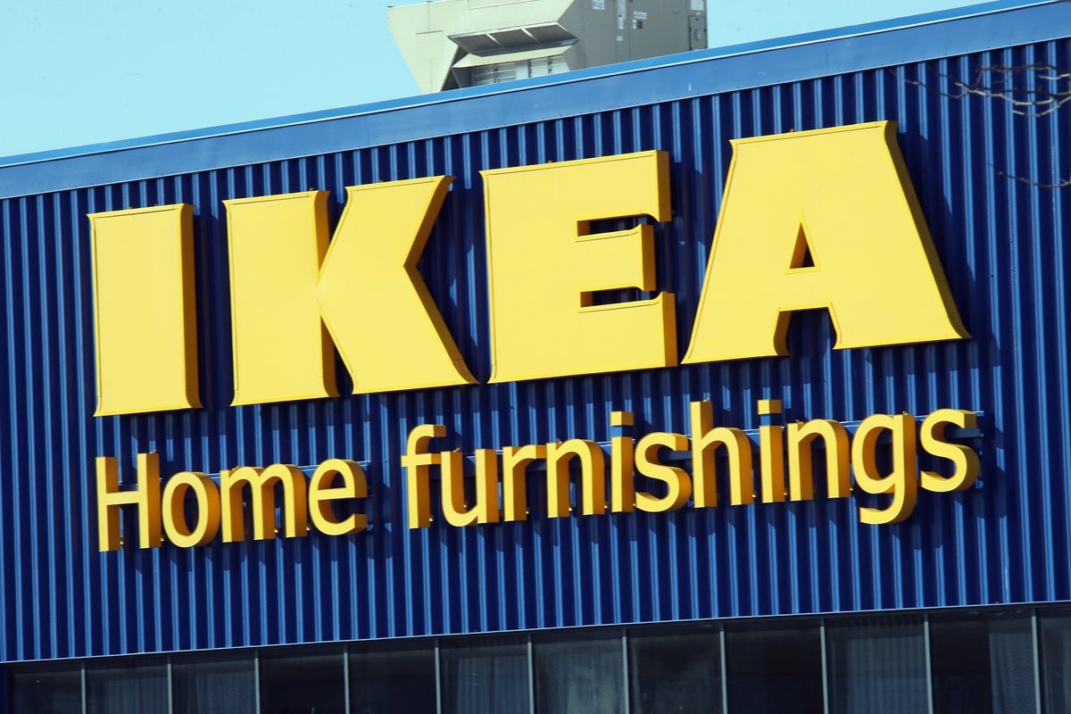 A crowd of people standing outside the IKEA store in Memphis, looking shocked and disappointed by the sudden store closure announcement, with a banner reading 'Store Closing' hanging above the entrance, as the community comes to terms with the loss of their beloved furniture store