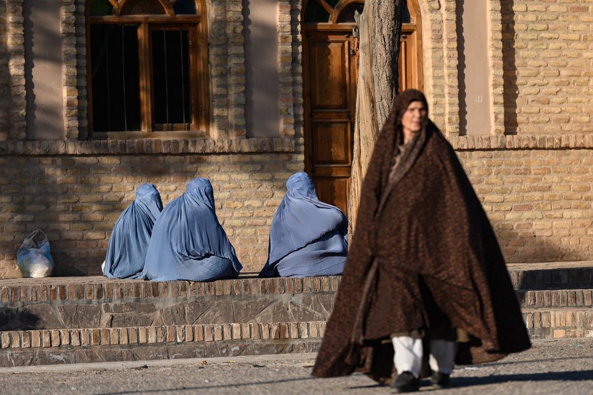 A woman in a burqa walks alone in a deserted street, symbolising the oppression and lack of freedom that women face under the Taliban's rule, with the Taliban's penal code legalising domestic violence and putting husbands on par with slave masters