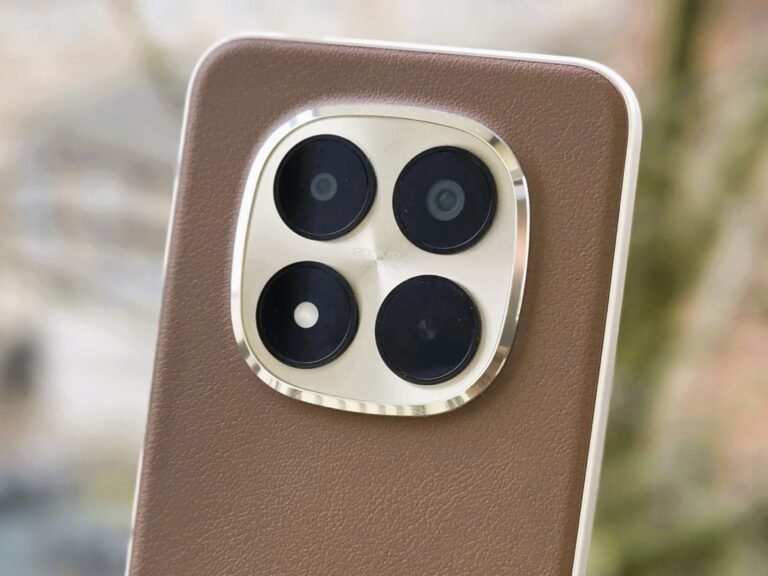 A close-up of the Xiaomi Redmi Note 15 Pro Plus camera, with a blurred background of a cityscape at sunset, showcasing the phone's 200MP sensor and advanced camera capabilities