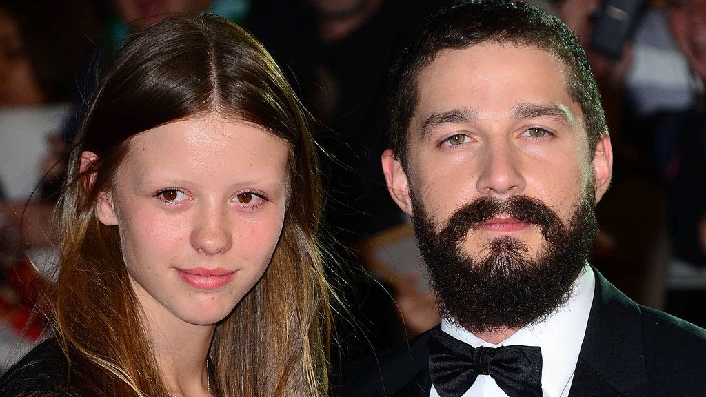 Shia LaBeouf and Mia Goth, a Hollywood couple who have recently split, are seen together at a red carpet event, showcasing their love and affection for each other, with a focus on their relationship and the challenges they faced as a couple in the public eye