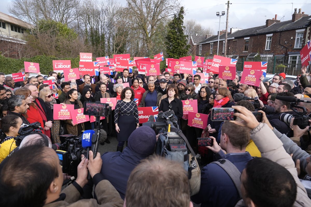 A person casting their vote in a polling station, with a Labour party logo in the background, highlighting the importance of shy Labour voters in the Gorton by-election