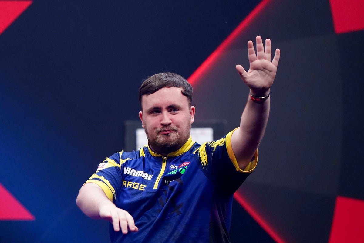 Luke Littler in action at the Premier League darts, throwing a dart with precision and focus, surrounded by a lively crowd, with the Premier League darts logo prominently displayed, highlighting the excitement and colour of the competition