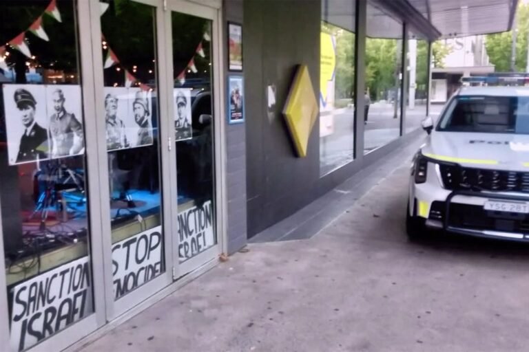 A descriptive image of a bar with posters of Trump and Netanyahu in Nazi uniforms, with a police car outside, highlighting the primary keyword phrase 'Australian bar crime scene'
