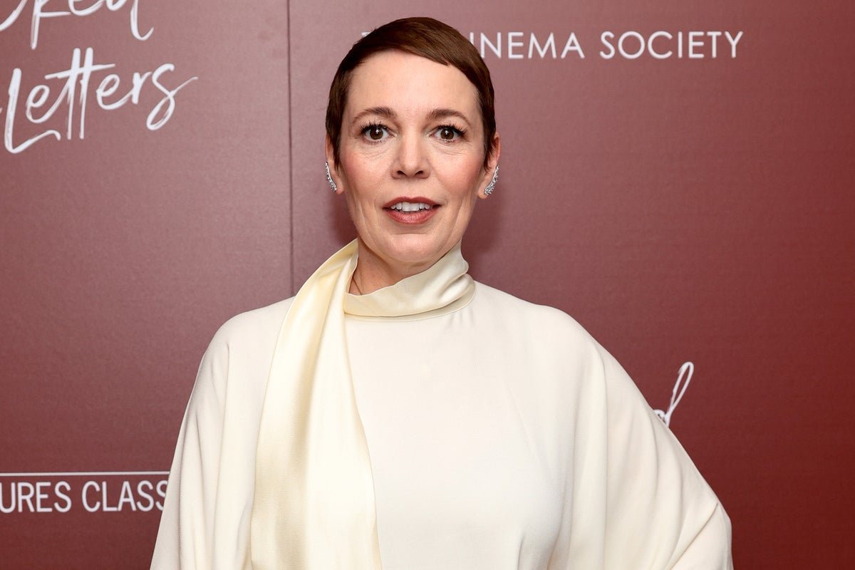 Olivia Colman at a recent event, surrounded by LGBTQ+ flags and symbols, highlighting her support for the community despite recent controversy