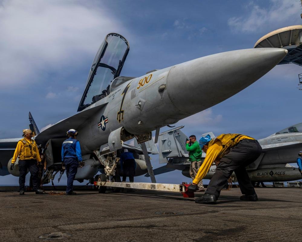 A dramatic image of the Iranian flag waving in the wind, with a subtle background of the US flag, symbolising the escalating tensions between the two nations, with the primary keyword Iran war featured prominently