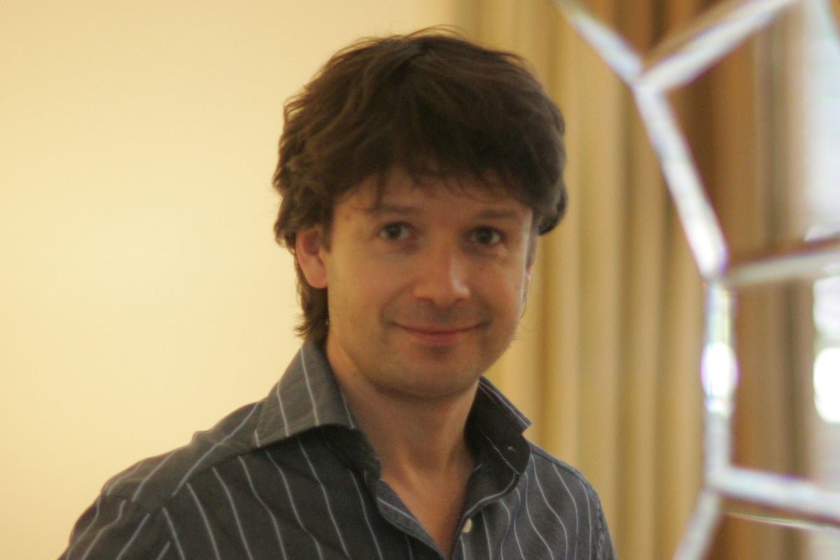 Quentin Griffiths, co-founder of ASOS, standing in front of a city skyline, symbolising his innovative approach to online fashion and his commitment to making fashion accessible to everyone, with a colourful and vibrant background