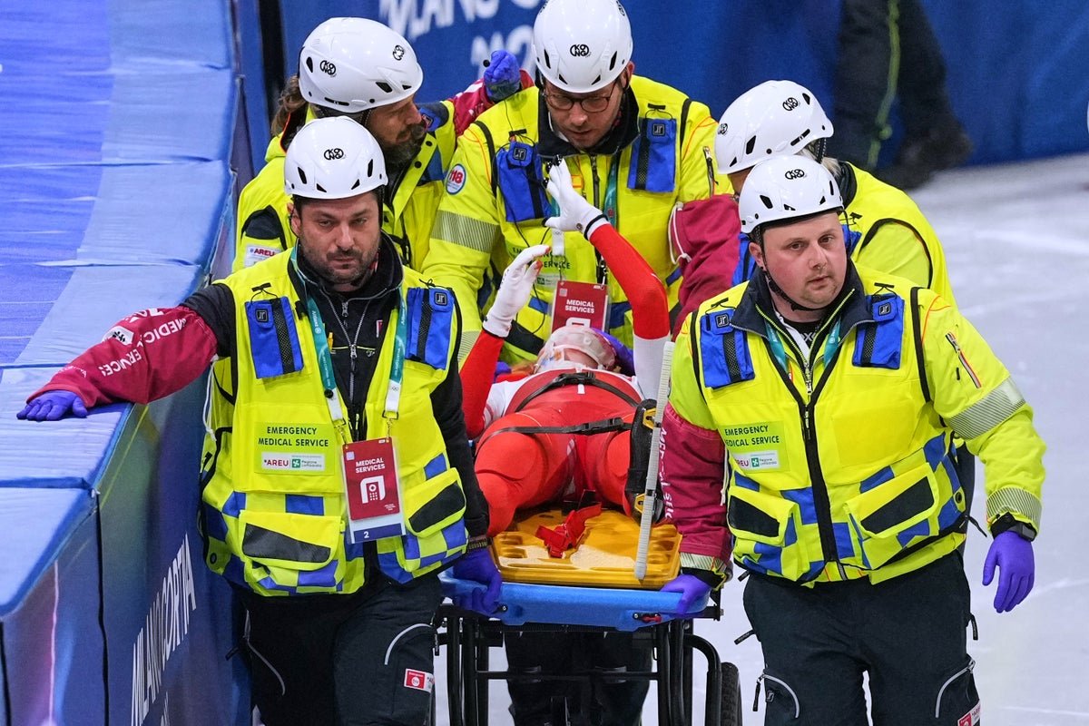A speed skater lies on the ice after a bloody accident at the Winter Olympics, with medical staff rushing to their aid, highlighting the risks of the sport and the importance of safety measures