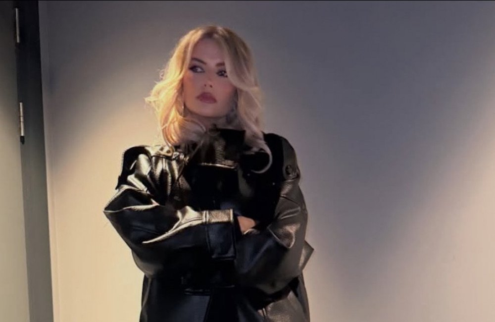 Lucy Fallon smiles as she talks about her mental health journey, with a calm and peaceful background, highlighting the importance of mental wellbeing and the need for supportive environments, with a mix of bright and muted colours, symbolising hope and recovery