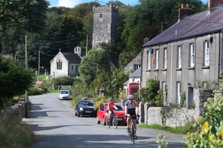 A descriptive image of the Welsh countryside with a polling station in the foreground, highlighting the importance of the Senedd election in rural Wales with voters casting their ballots