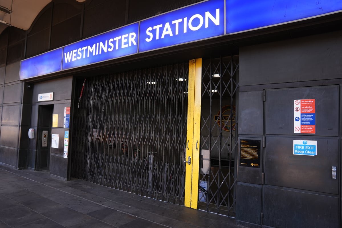 A crowded London Tube station with a sign reading 'Tube Strike' in the foreground, highlighting the transport disruption caused by the RMT union's decision to back a walkout over a four-day week, with commuters waiting anxiously for news of the strike