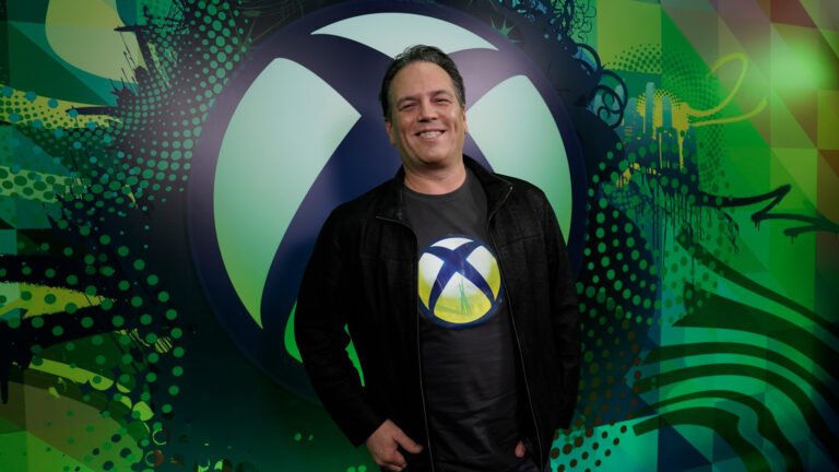 Phil Spencer, the former head of Xbox, is retiring after a 38-year career in the UK gaming industry. He is pictured here at a gaming event, surrounded by fans and colleagues. The image captures the colour and vibrancy of the UK gaming scene, which Spencer has been instrumental in shaping. His legacy will continue to inspire future generations of gamers and developers.
