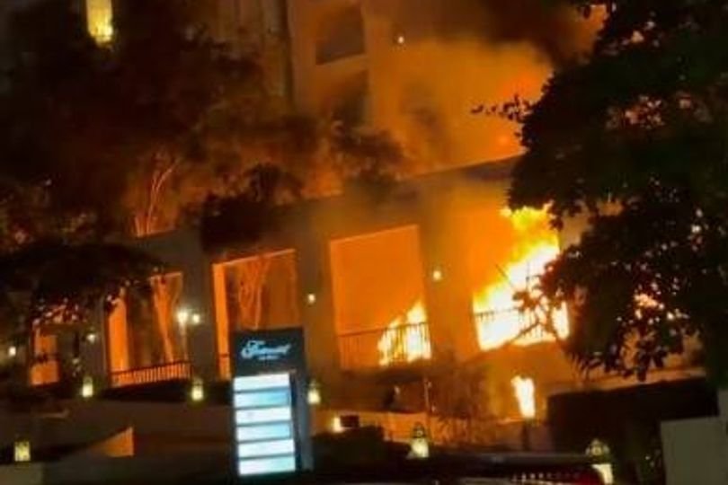 The Dubai Fairmont Hotel on fire after a suspected missile attack, with flames and smoke billowing from the building, as emergency services respond to the incident, highlighting the need for increased safety measures in public places, particularly in areas prone to such attacks, with the primary keyword being Dubai Fairmont Hotel fire
