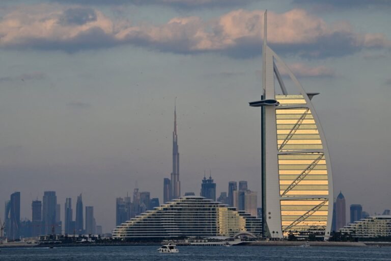 The Burj Al Arab hotel in Dubai engulfed in flames after being hit by a shot-down Iranian drone, with fire fighters and emergency services at the scene, highlighting the need for increased security measures to prevent such incidents