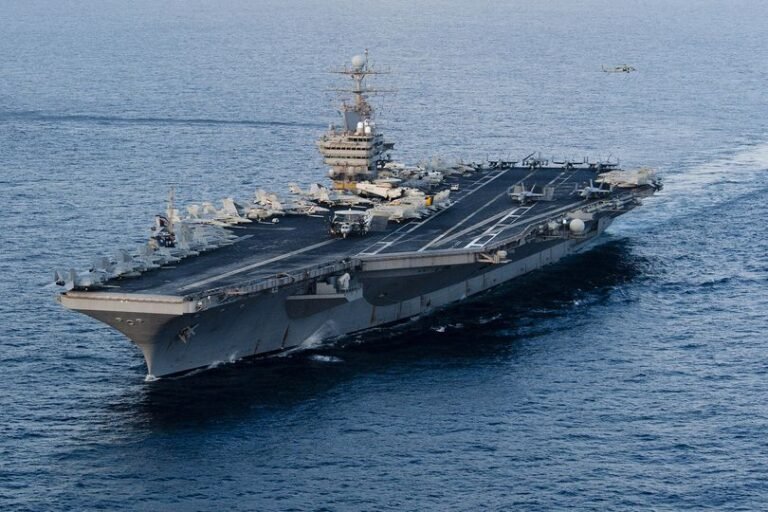 The USS Abraham Lincoln aircraft carrier is seen in the Persian Gulf, with a ballistic missile flying in the background, as tensions between the US and Iran escalate, with the primary keyword being USS Abraham Lincoln