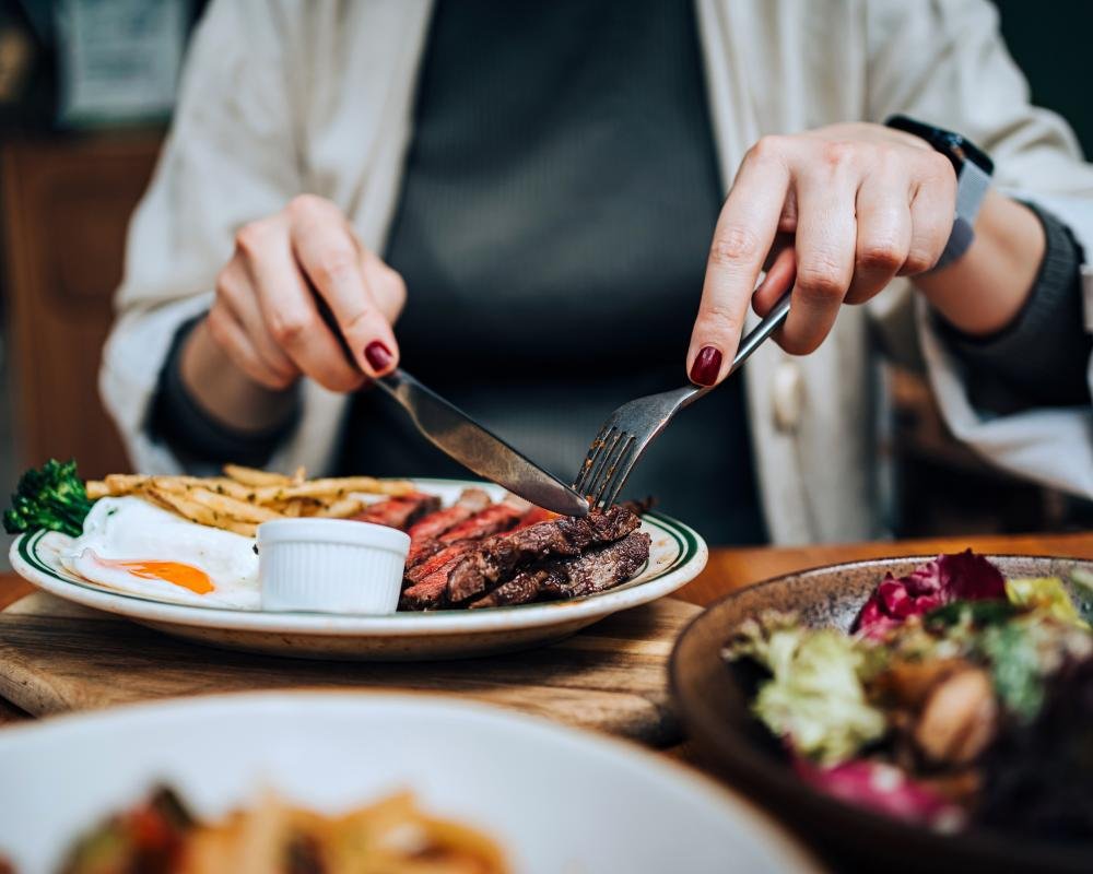 A woman practising yoga outdoors, highlighting the importance of a healthy lifestyle in reducing the risk of breast cancer, with a focus on wellbeing and cancer prevention
