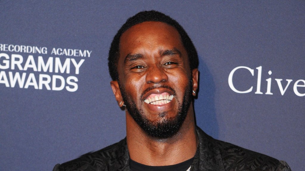 Sean 'Diddy' Combs smiling and waving as he exits the prison gates, marking the beginning of a new chapter in his life, with a bright colour and a sense of hope and freedom, as he prepares to make his return to the entertainment industry, with his primary keyword being prison release