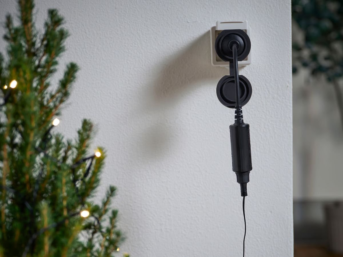 IKEA's Tofsmygga Plug, a black outdoor smart plug with Matter compatibility, designed for remote control of outdoor devices and seamless integration with smart home products