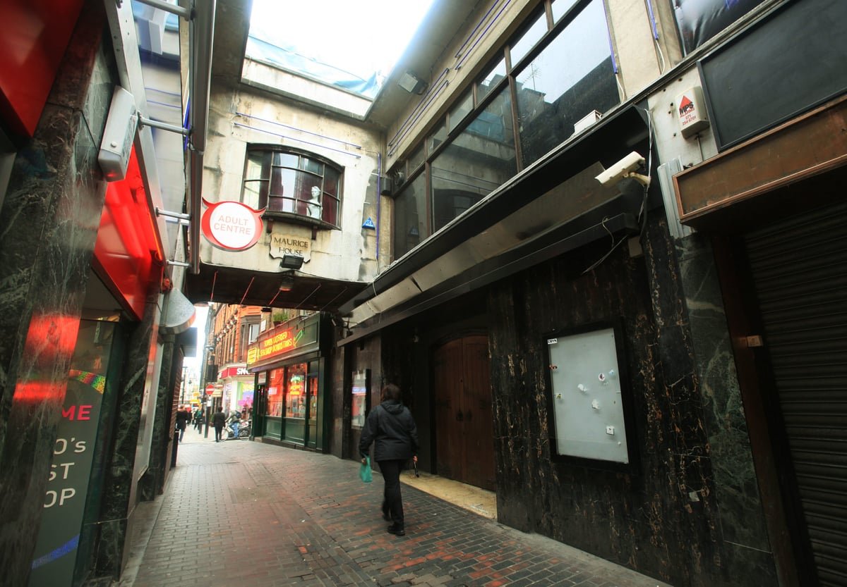 A crowded Soho street at night, with people walking outside The Box nightclub, a renowned venue with a colourful history and reputation, currently embroiled in controversy surrounding allegations of sexual assault