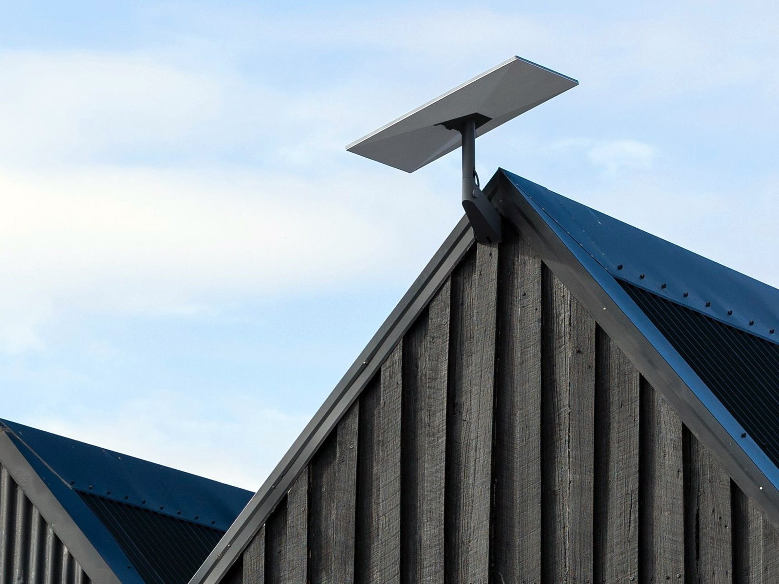 A photo of the Starlink satellite Internet dish, providing fast and reliable Internet connectivity to users in the UK, with a clear blue sky and a few clouds in the background, representing the company's commitment to providing high-quality Internet services