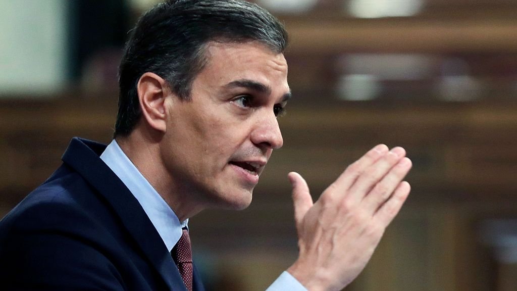 Spanish Prime Minister Pedro Sánchez standing firm against war, with a backdrop of the Spanish flag and a symbol of peace, highlighting his commitment to diplomacy and cooperation, with a focus on the keyword 'peace'