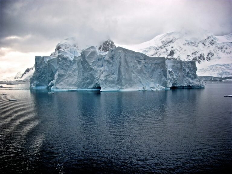 Aerial view of Antarctica's ice sheet, with a focus on the primary keyword 'ice sheet' in the context of climate change and its impact on the UK's coastal regions, featuring a stunning colour palette of whites and blues