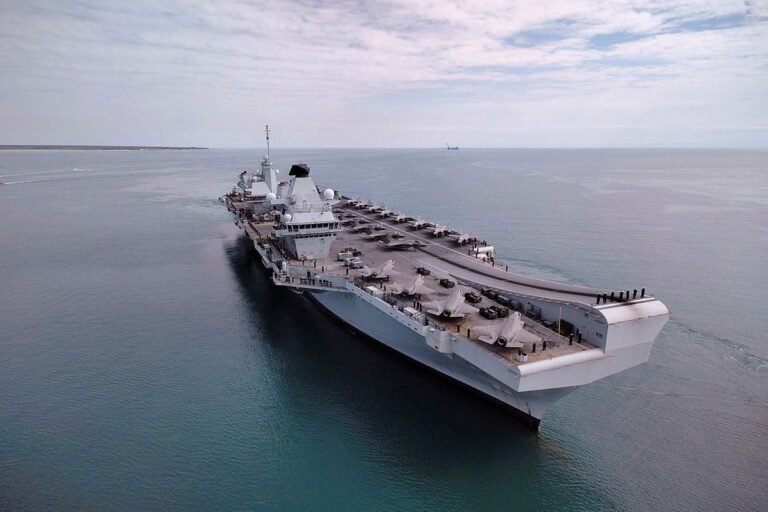 The UK's aircraft carrier, equipped with state-of-the-art technology, sets sail for the Middle East, demonstrating the country's commitment to regional security and defence, with a fleet of support ships and aircraft in the background