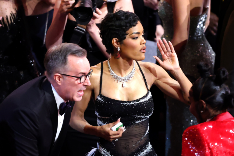 Teyana Taylor posing on the red carpet at the Oscars, with a shocked expression on her face, amidst a crowd of people, representing the chaos and controversy surrounding the backstage altercation, with a focus on celebrity news and entertainment
