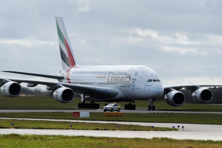 Birmingham Airport terminal building with a plane taking off in the background, with a caption mentioning Emirates flights and Iran conflict