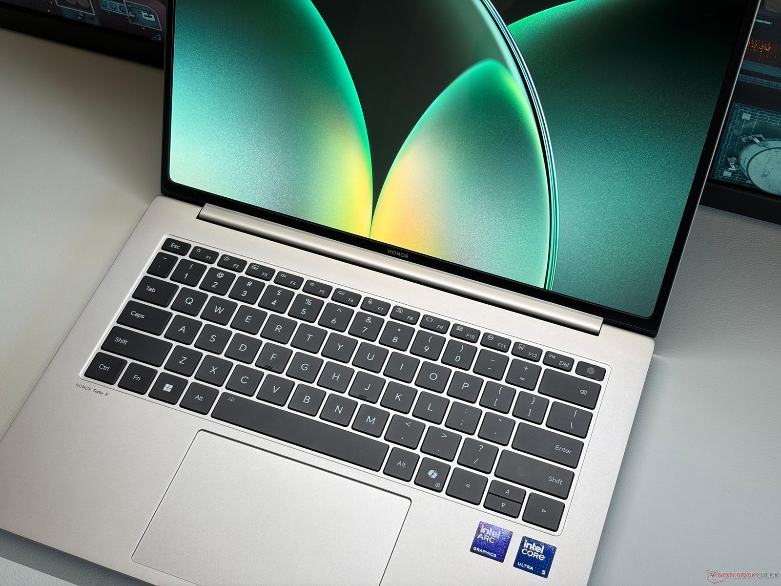 A side-by-side comparison of the Honor MagicBook Pro 14 and Apple MacBook Pro 14 M5 laptops, showcasing their sleek designs and vibrant displays, with a focus on the primary keyword: UK laptops
