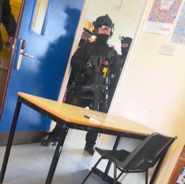 A teenage girl being helped by a teacher after a stabbing incident at school, with a focus on school safety and preventing violent behaviour