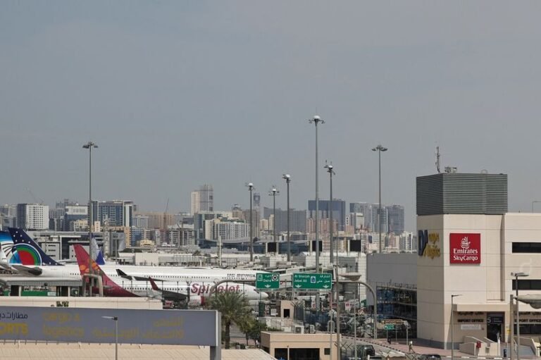 Aerial view of Dubai's stunning skyline, featuring the Burj Khalifa, with a plane flying in the background, symbolising the return of travel to the UAE, a popular destination for tourists and business travellers, with its rich culture and world-class amenities
