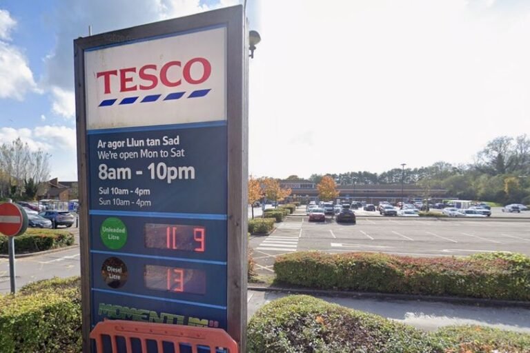 A Tesco store with a damaged car in the car park, highlighting the need for improved customer safety and security measures to prevent violence and abuse