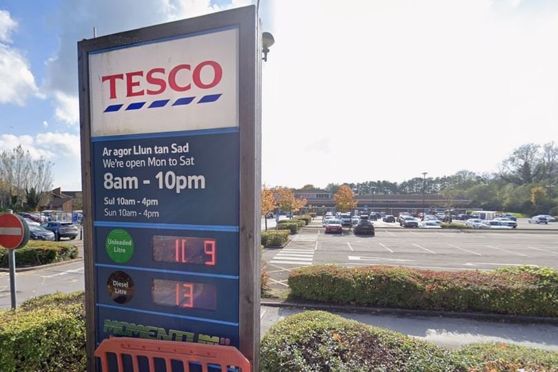 A Tesco store with a damaged car in the car park, highlighting the need for improved customer safety and security measures to prevent violence and abuse