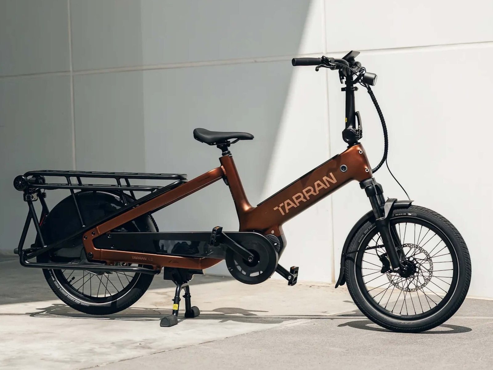 The Tarran L1S e-bike in action, showcasing its sleek design and advanced features, including mmWave radar technology, as it navigates through a bustling UK city with ease and style, highlighting its electric cargo bike capabilities