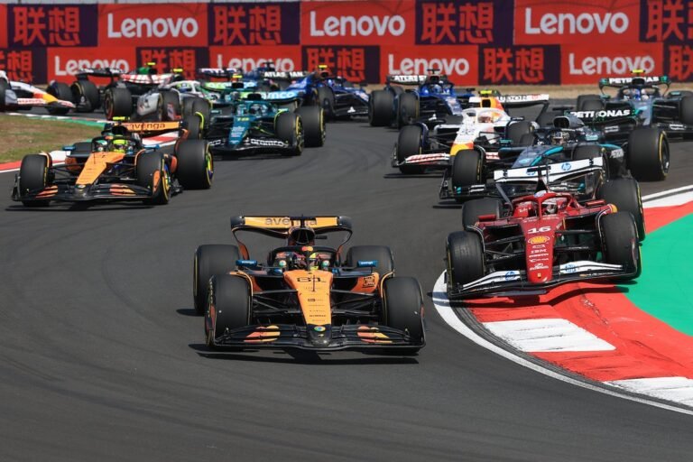 Chinese Grand Prix live streaming: watch F1 online with a dramatic image of a racing car speeding around a track, with a cityscape in the background, showcasing the colour and excitement of the event