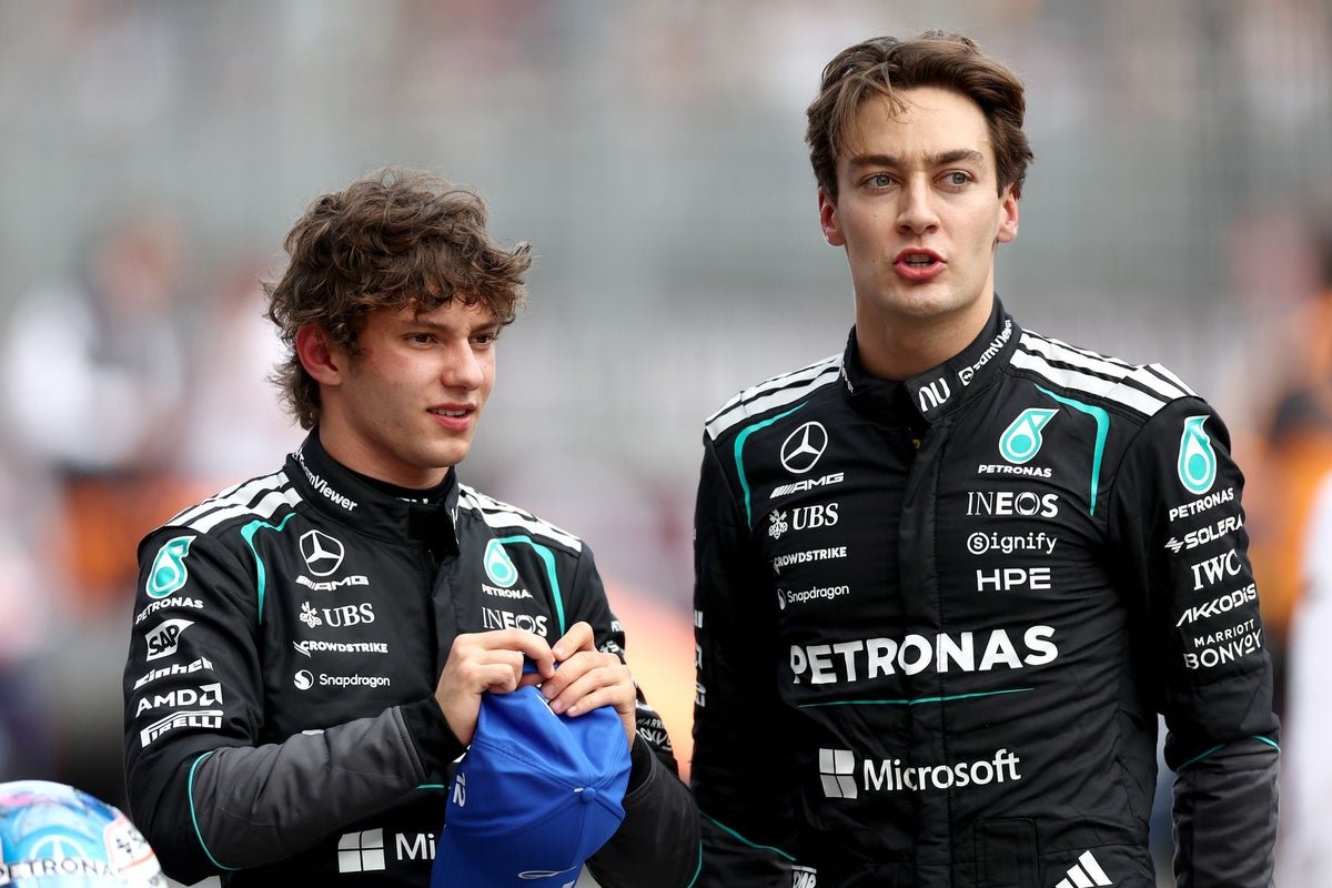 Kimi Antonelli and George Russell racing at the Chinese GP, with a cheering crowd in the background, under the bright colour of the racing flags, showcasing their best behaviour on the track