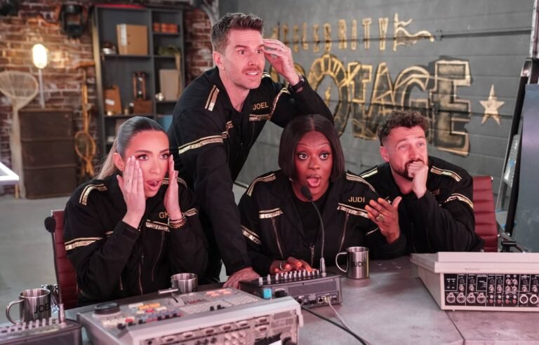 Joel Dommett smiling and waving at the camera, with a colourful background, after his shocking London Marathon experience, where he had to be woken up in an ambulance, and his subsequent brave appearance on Celebrity Sabotage, a comedy programme