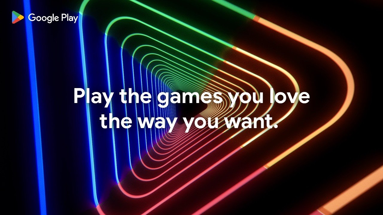 A person playing a game on their mobile device, with a PC in the background, illustrating the Buy Once, Play Anywhere feature that allows for seamless gaming across devices, enhancing the overall gaming experience with Google Play