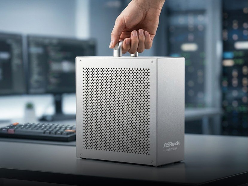 The ASRock AI BOX-A395 mini workstation PC features a stylish aluminium case and handle, with a powerful AMD Ryzen AI Max+ 395 APU and up to 128 GB LPDDR5X-8000 RAM, making it perfect for professionals working with AI and machine learning in the UK, with a sleek colour scheme and compact design