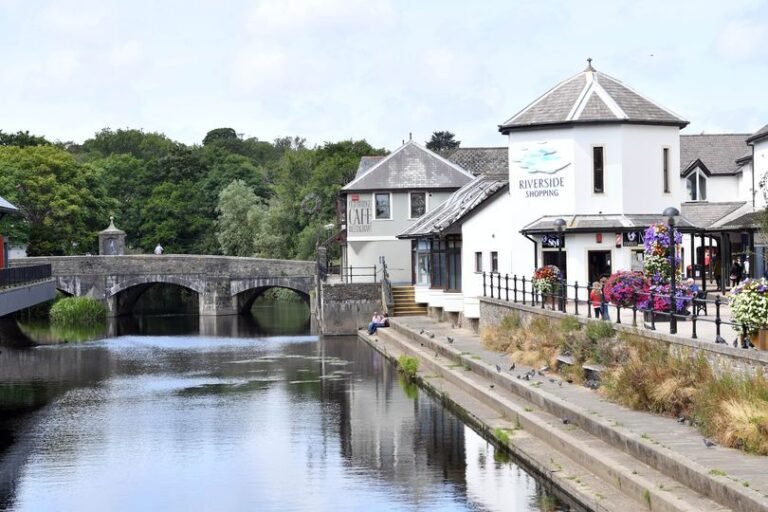 A sombre and reflective scene in the town centre, with emergency services present and a river rescue operation underway, highlighting the importance of water safety and river rescue efforts