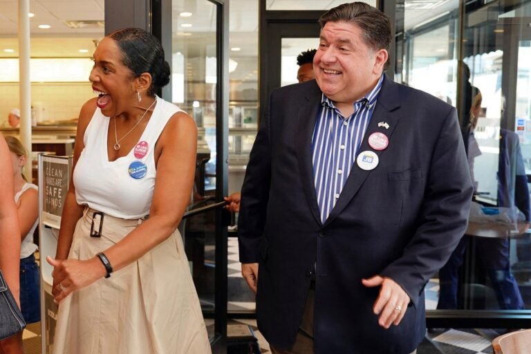 Juliana Stratton smiling and shaking hands with supporters, with a banner reading Illinois Democratic Senate primary in the background, showcasing her campaign's emphasis on community engagement and voter participation
