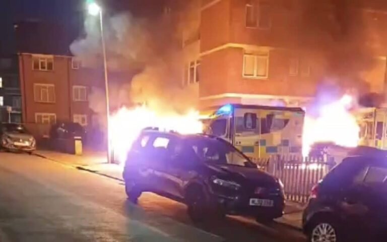 A London synagogue with ambulances parked outside, a scene of an anti-Semitic attack where vehicles were set on fire, highlighting the need for greater awareness and education about hate crimes and the importance of promoting tolerance and understanding within the Jewish community
